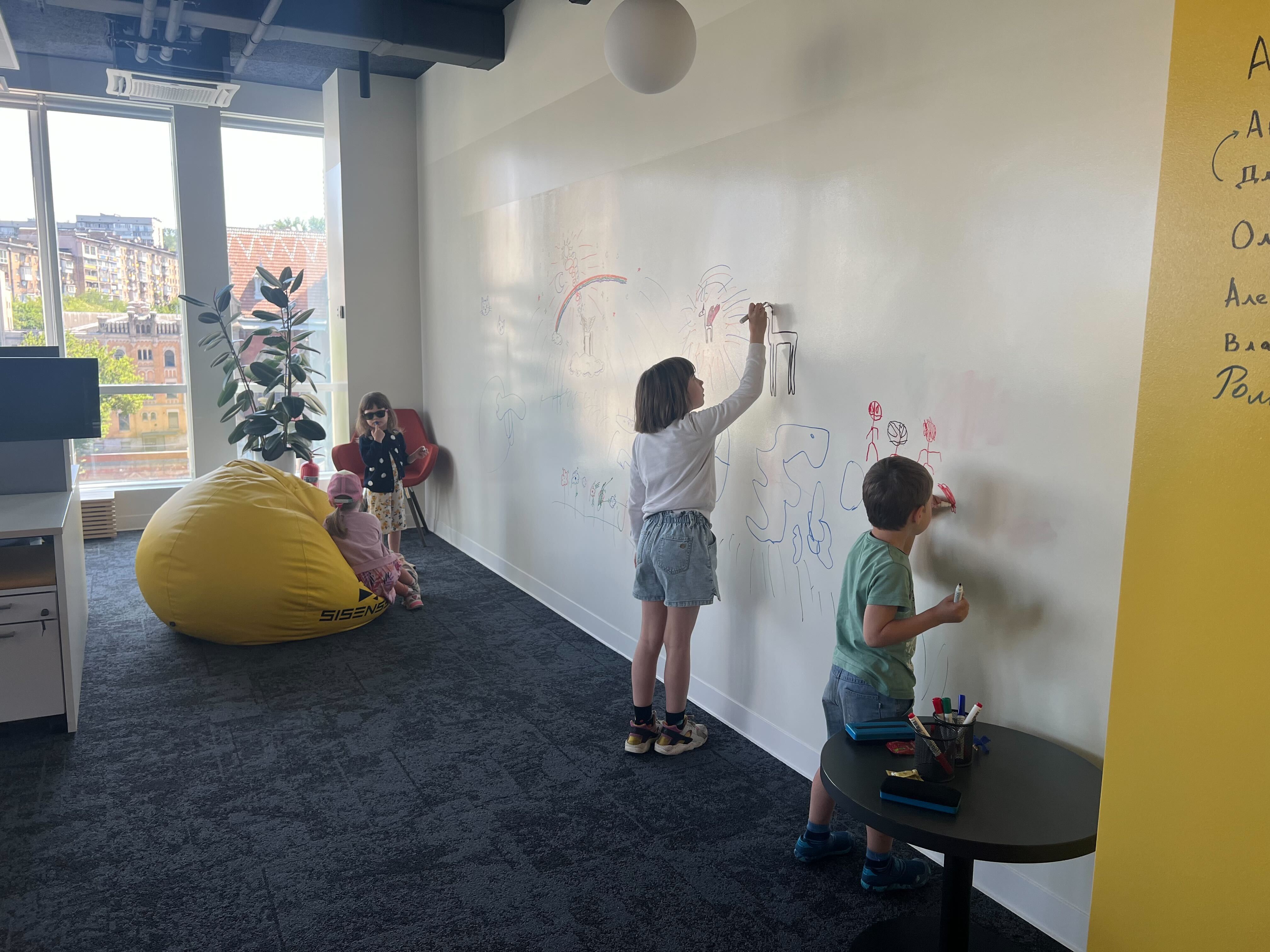 Kids draw on the whiteboard at Sisense offices for the company’s “kids day” event.