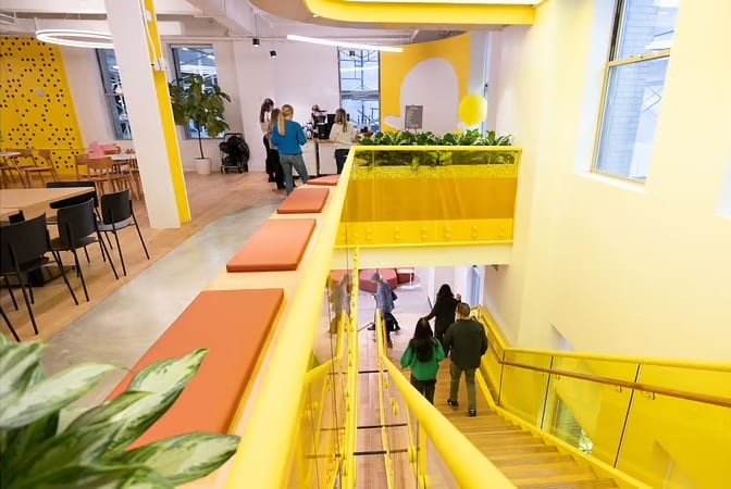 Snap’s office interior, featuring yellow walls and stairway up to dining area
