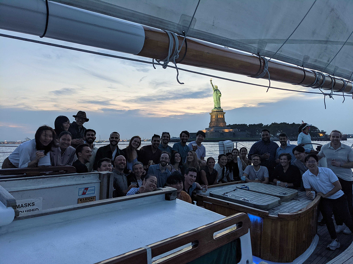 ActionIQ team members on a sailboat with the Statue of Liberty in the background