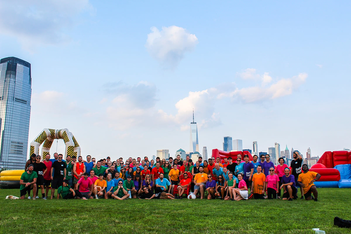 Bizzabo team members at an inflatable obstacle course with the New York skyline in the background