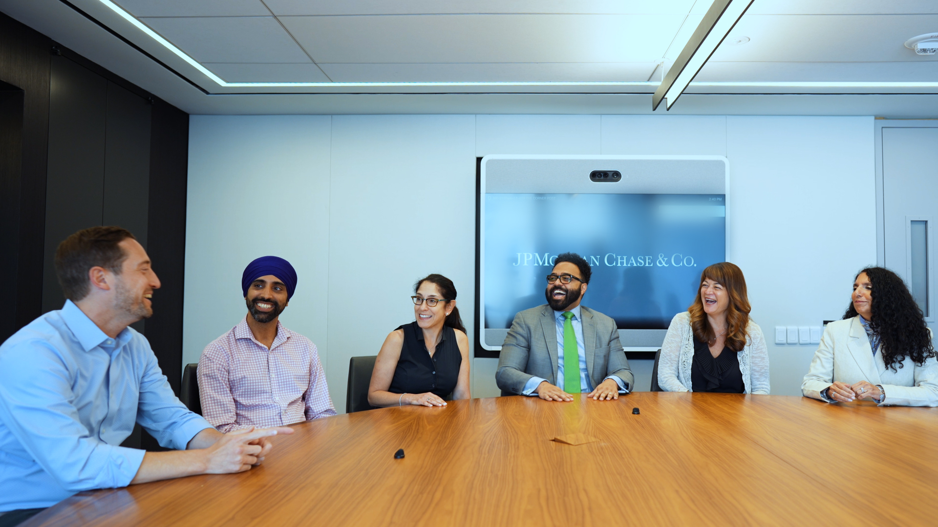  JPMorgan Chase’s CTC team sits around a conference table, talking and laughing.
