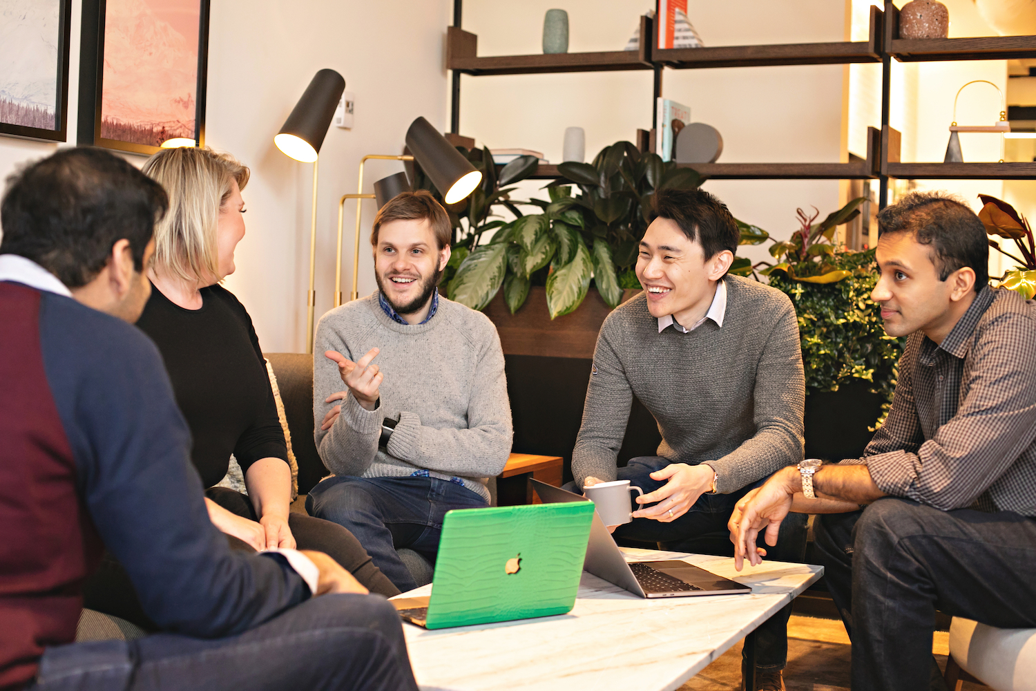 Chronosphere co-founded by CTO Rob Skillington and CEO Martin Mao gather around a table in the office with other employees.