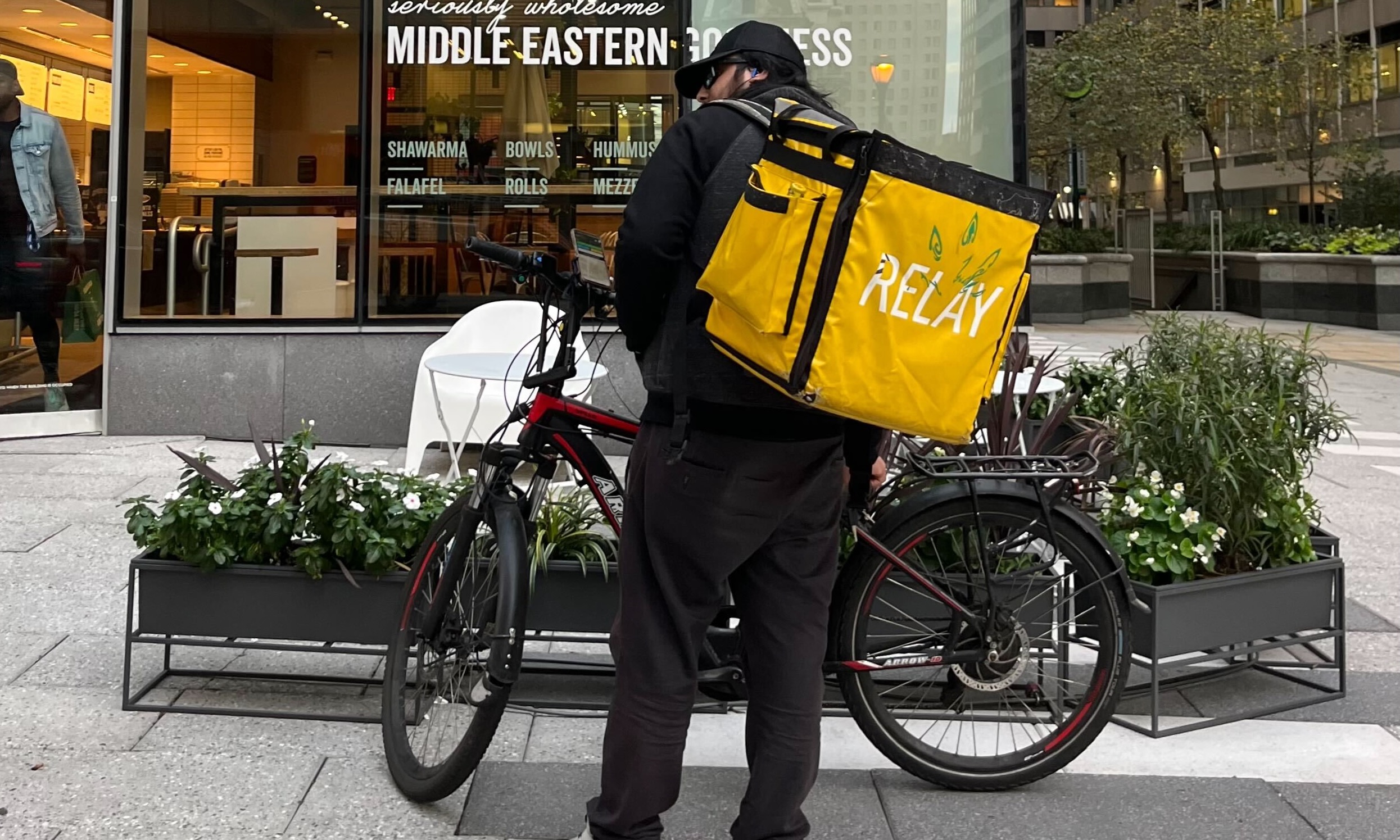Photo of Relay Delivery courier near bicycle in front of restaurant
