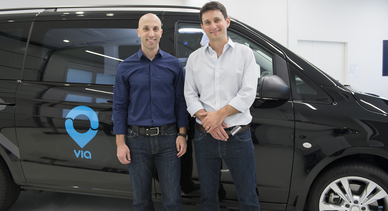 Via CEO Daniel Ramot and CTO Oren Shoval stand in front of a car with the Via logo.