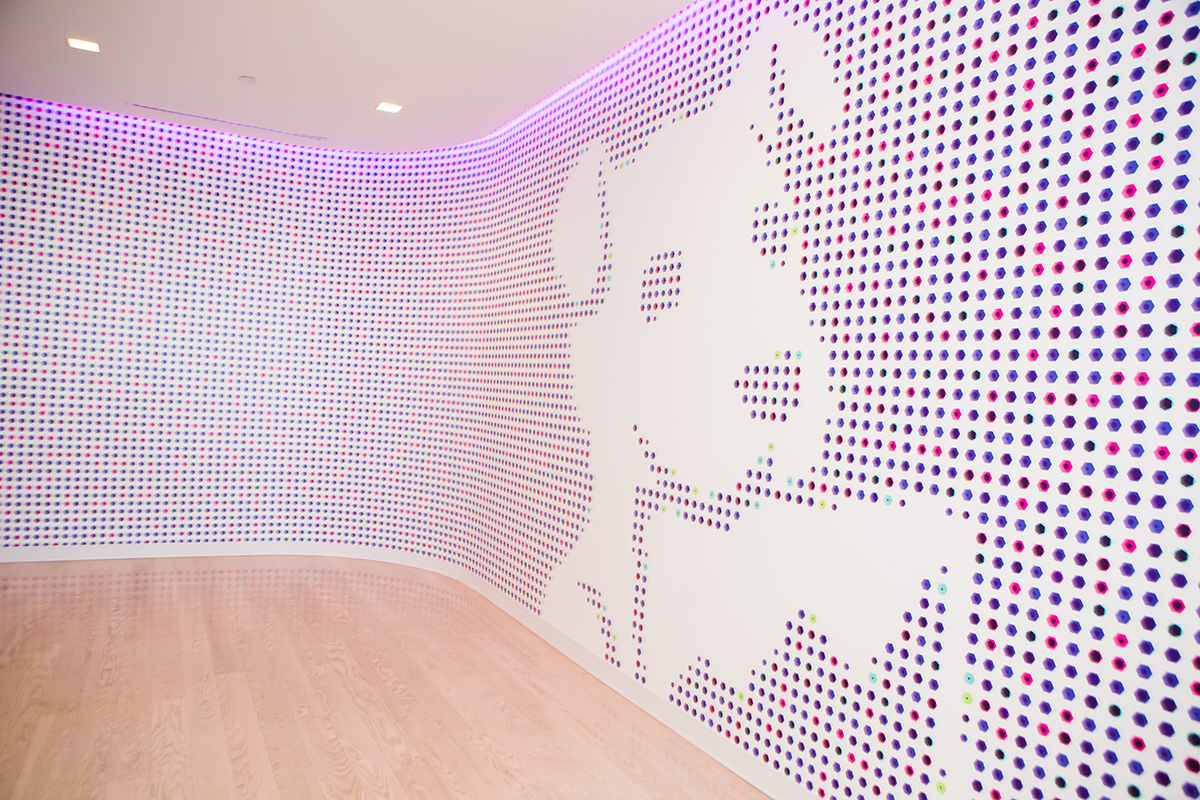 Wall in Datadog office covered in multi-colored dots with the company logo in white