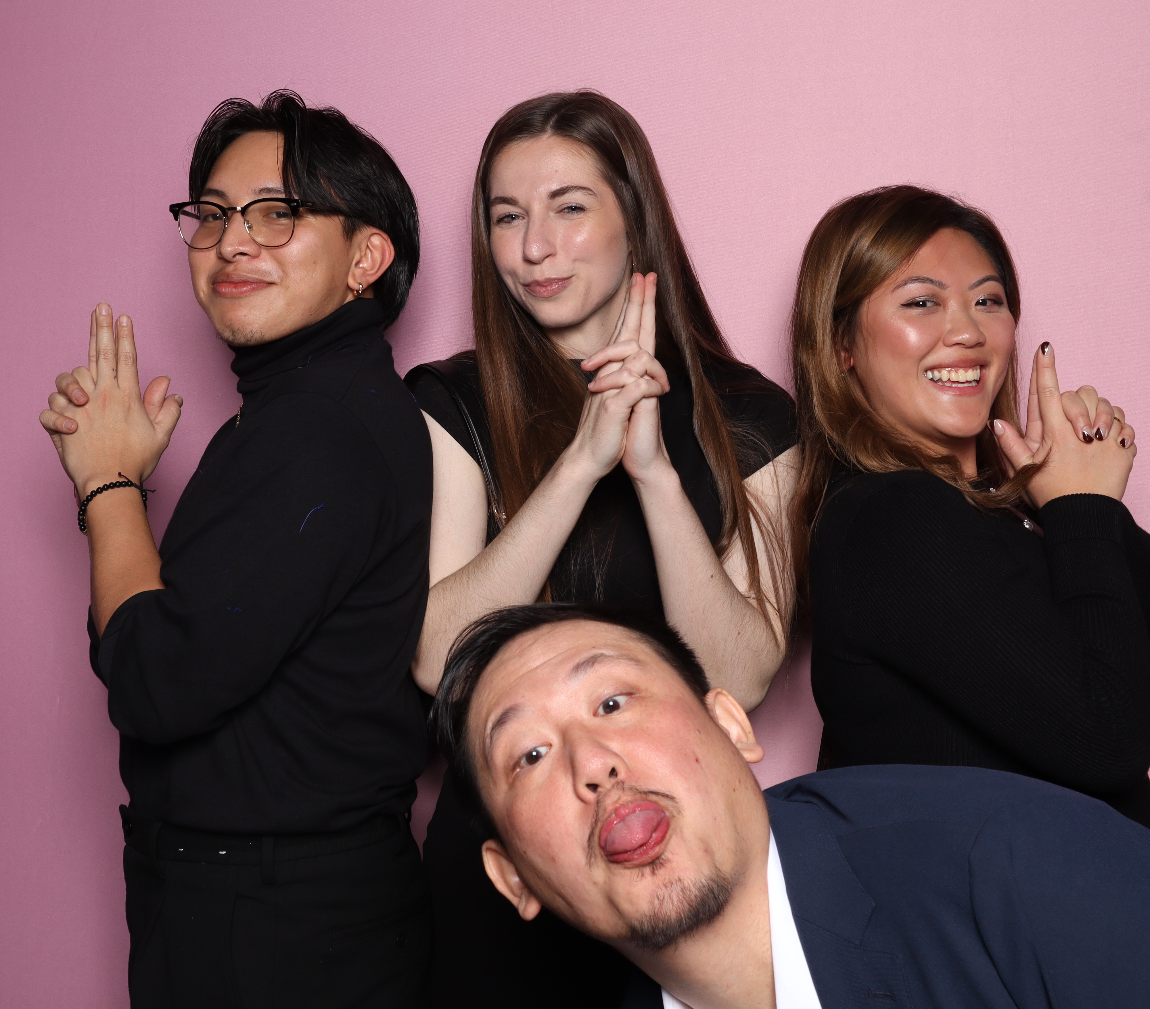 Four of OpenWeb's employees. Three of them are in a Charlie's Angels pose, holding finger guns; the fourth is in front, lower down in the frame, entering the picture from the side and sticking out his tongue.