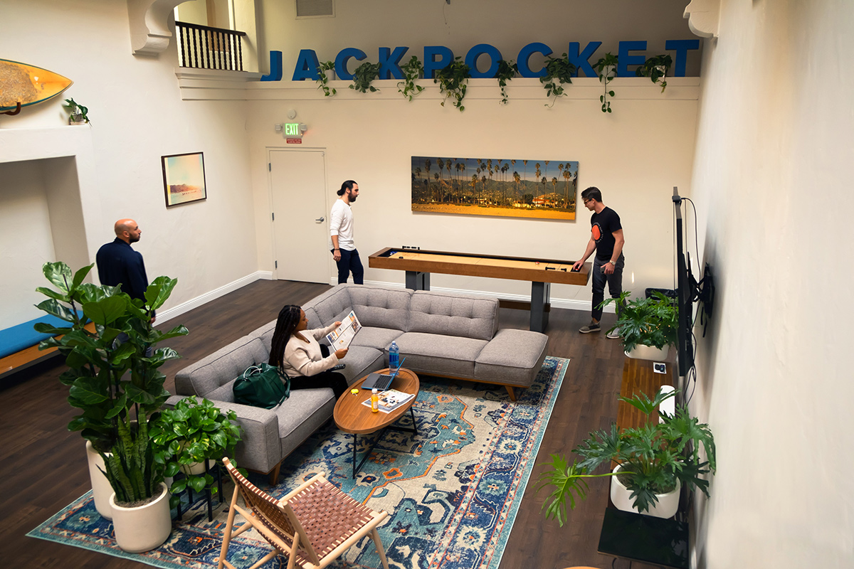 Inside of the Jackpocket office with two team members playing table shuffleboard