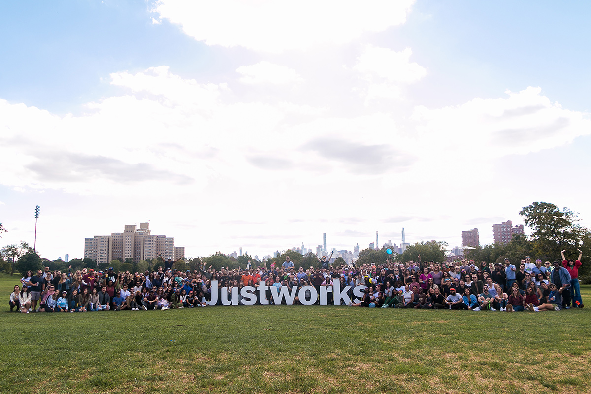Group photo with team members around letters that spell Justworks