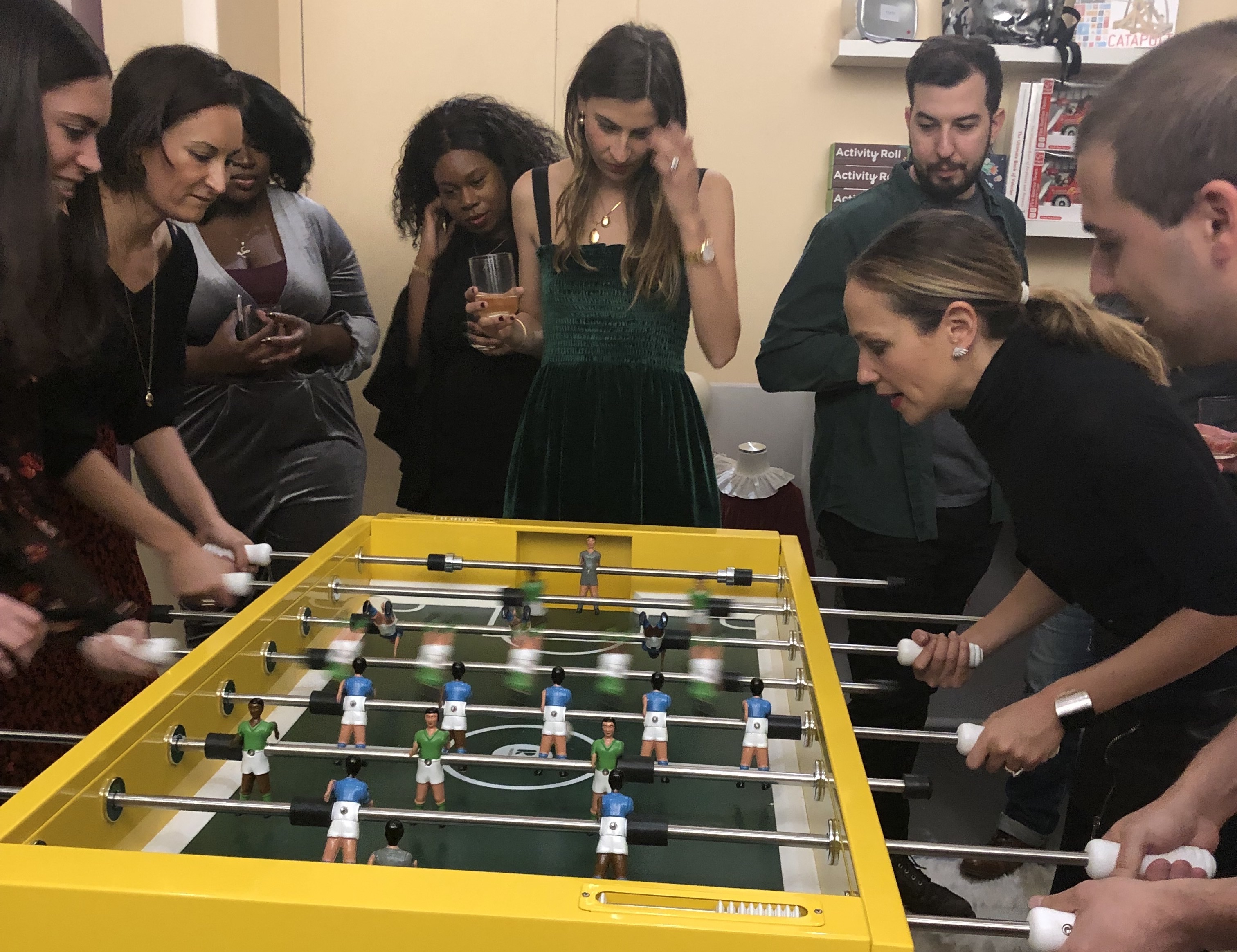A group of Maisonette employees play foosball together.