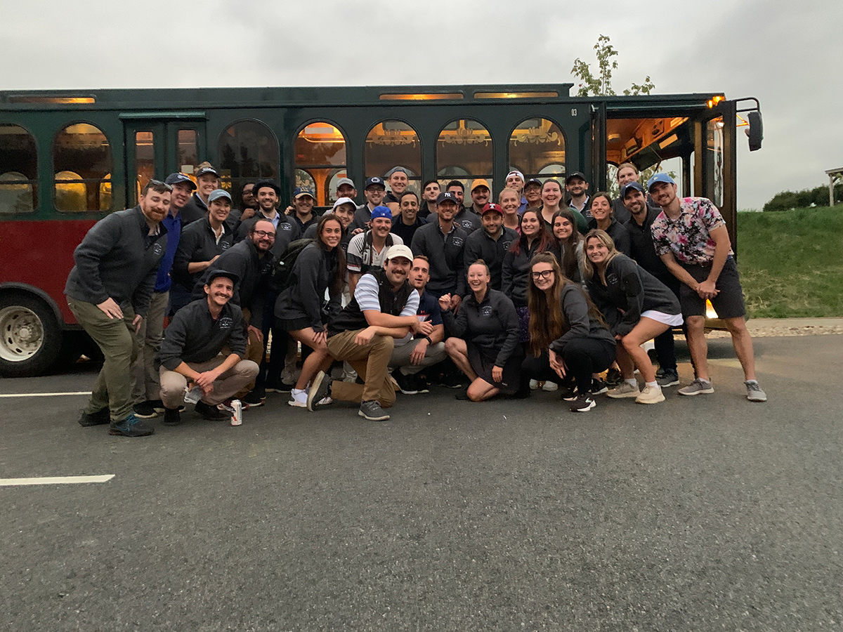 Order team photo outside by a trolley car