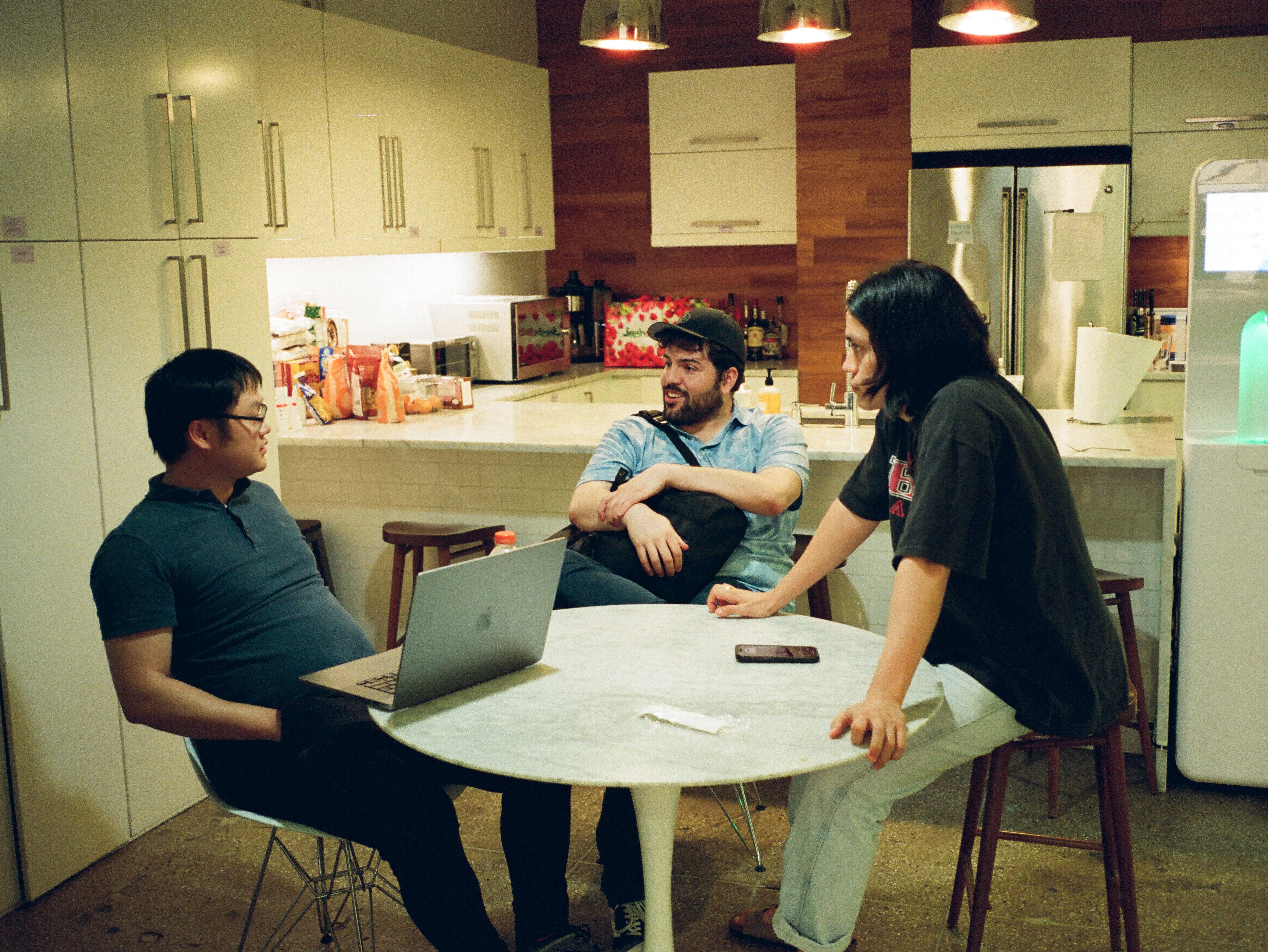 Pinwheel team members chatting at a table in the office kitchen