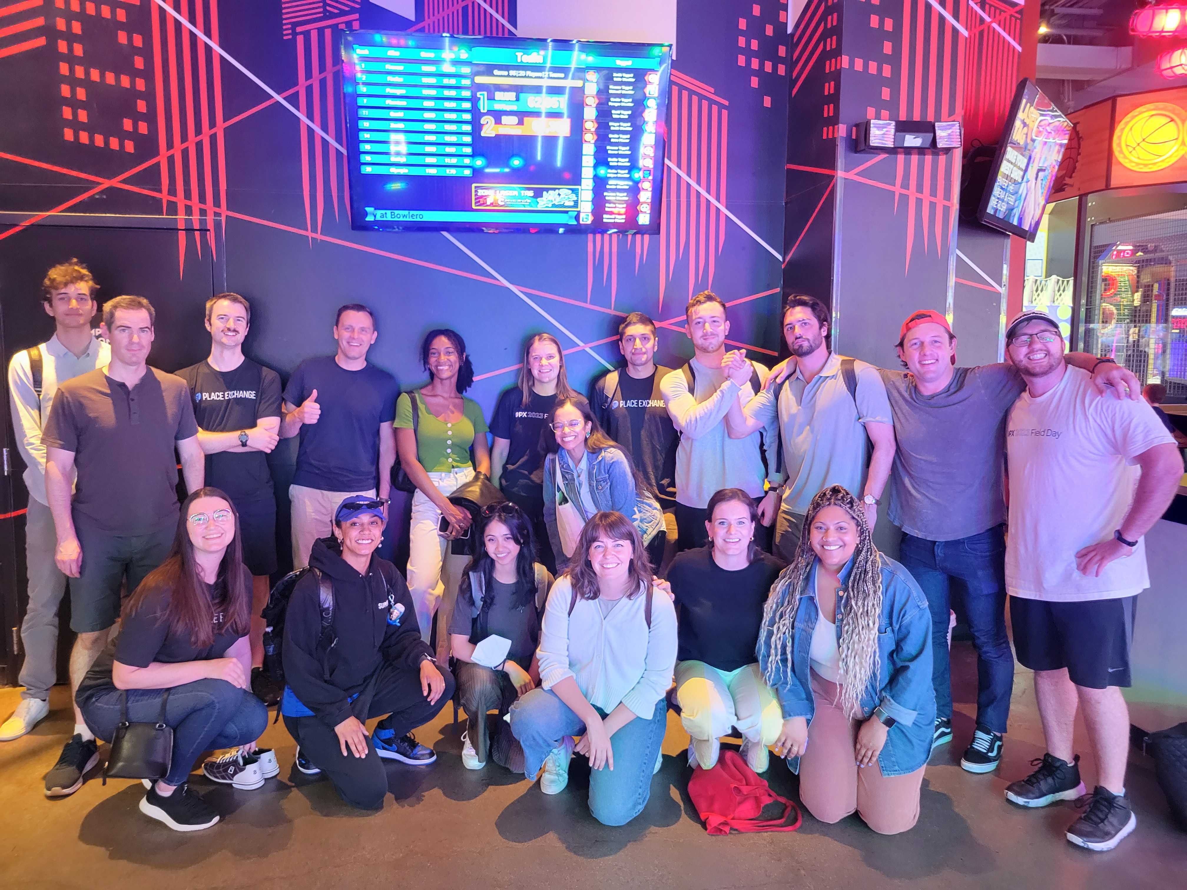  Group photo of Place Exchange team members standing beneath TV screen.
