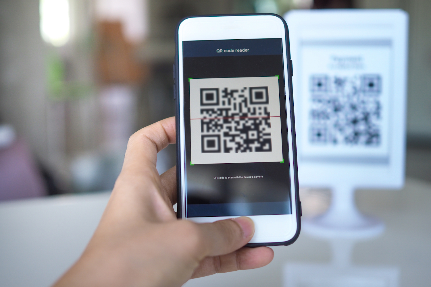 A person captures a QR code on their iPhone.