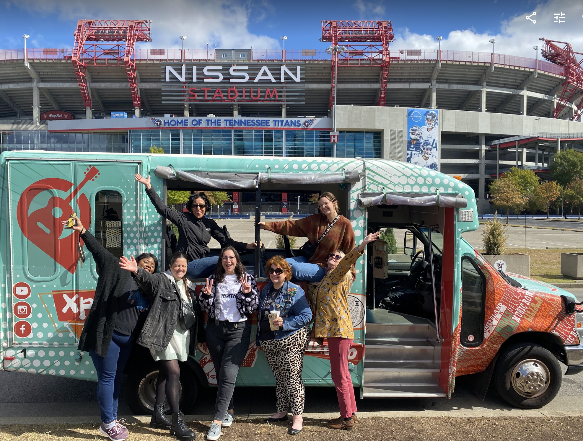 Seven of Postscript's employees posed outside of a bus near Nissan Stadium.