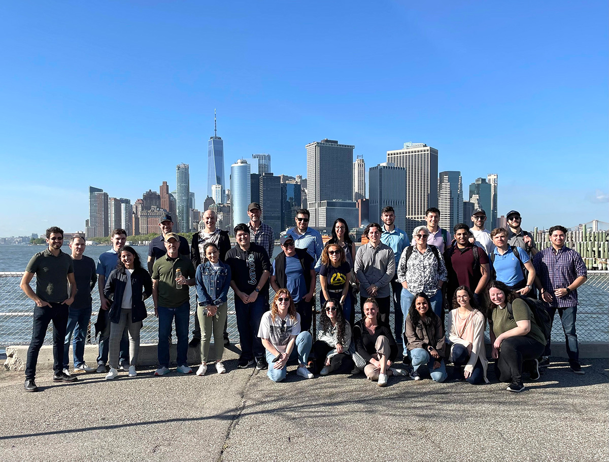 T-Rex group photo outside with the NYC skyline in the background