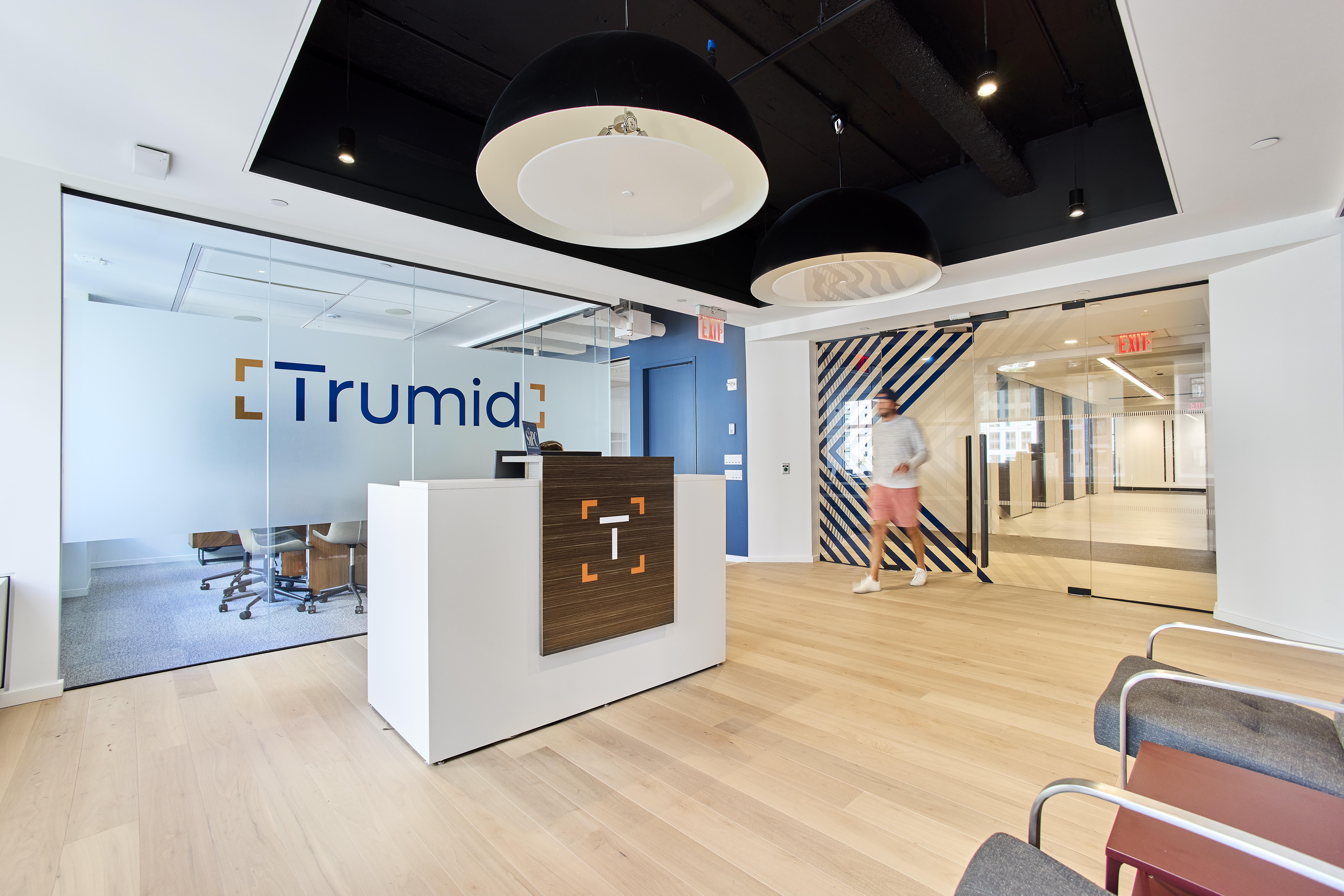 Trumid office photo showing logo, wood floors and vaulted ceiling.