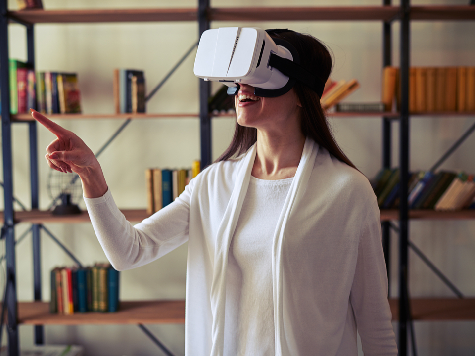 A woman in a white sweater using a virtual reality headset