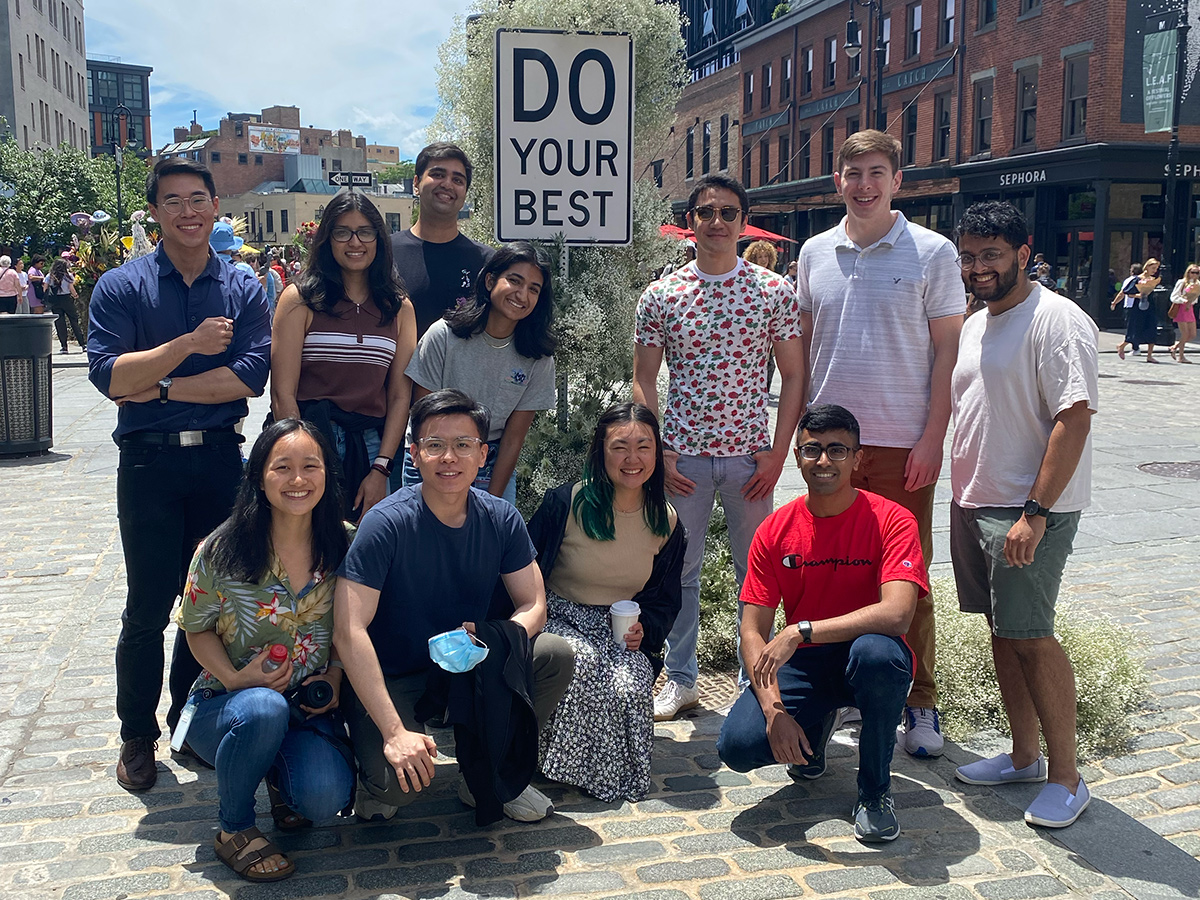 Yext team member photo outside with a street sign that says "Do Your Best"