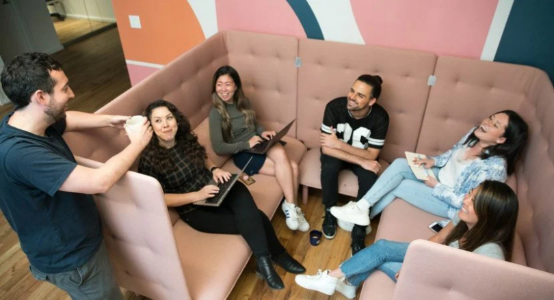 A group of Yotpo employees chat during a meeting.