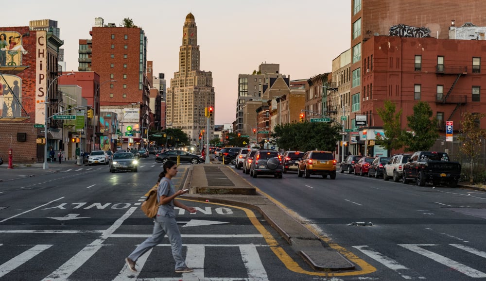 woman crossing the road at sunset in brooklyn