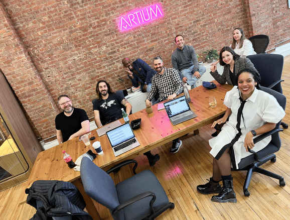 Artium team members gather around a conference table. 