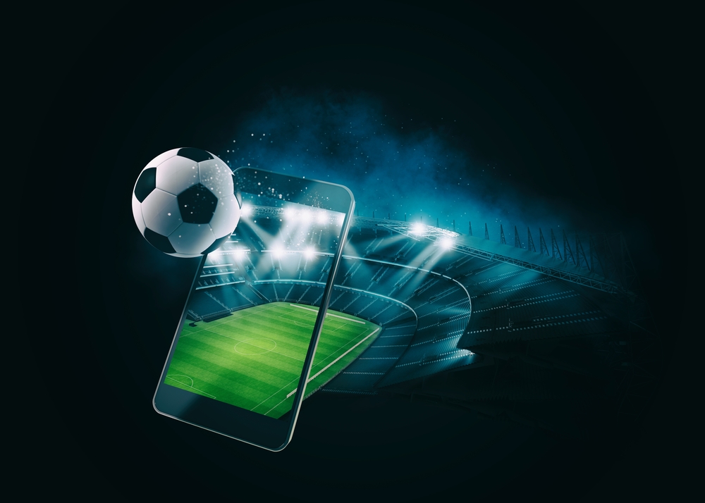 A soccer ball launches out of a phone screen. 