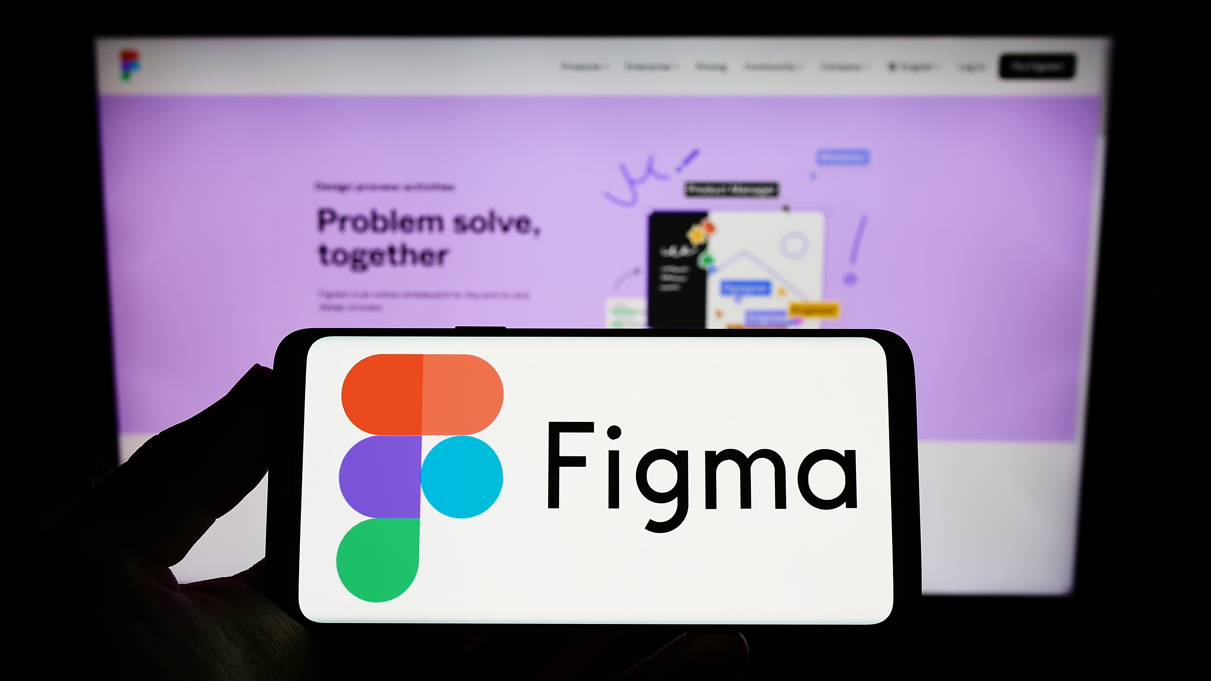 A phone with the Figma logo in front of a computer with the Figma homepage open