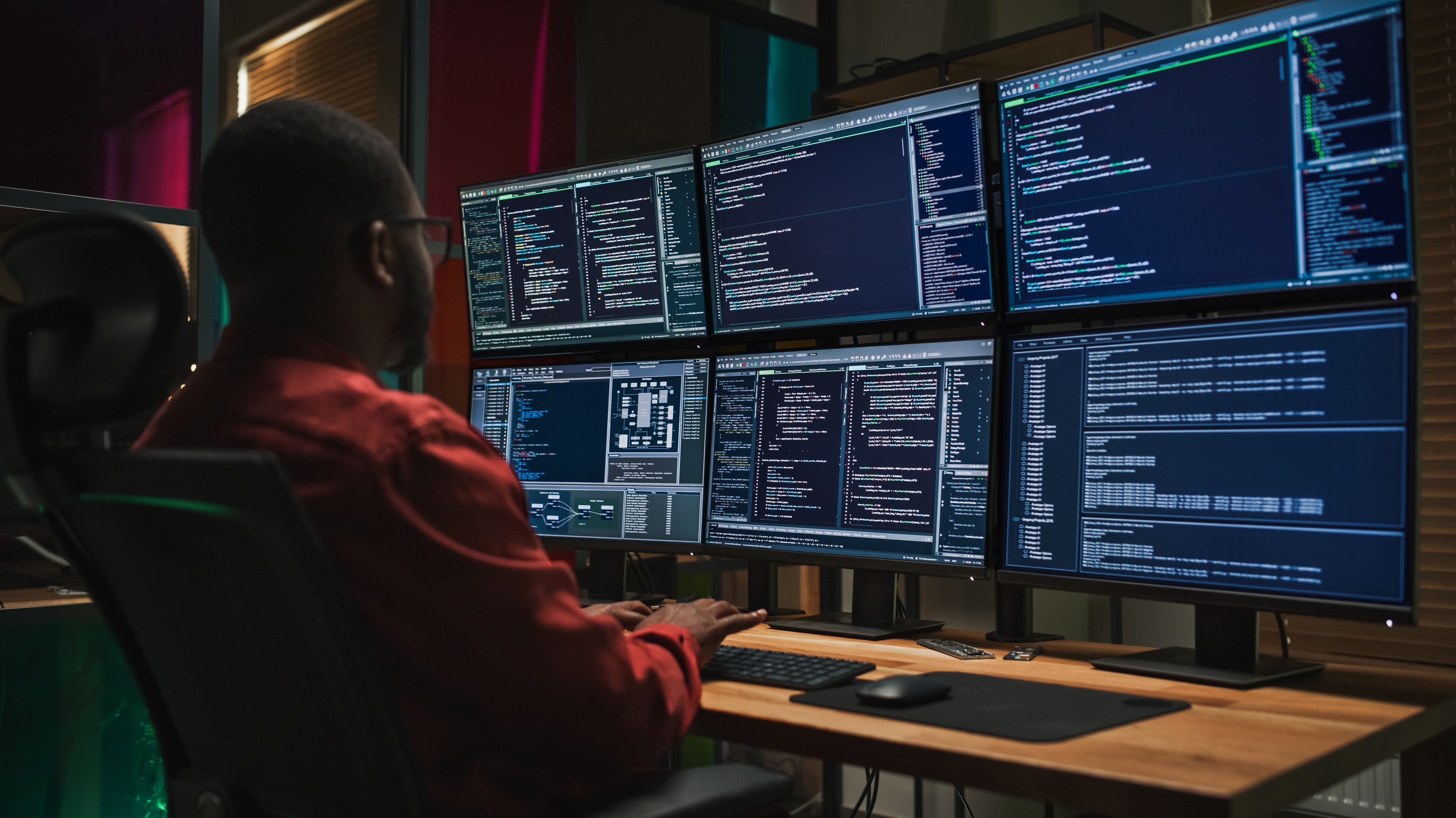 A cybersecurity analyst working with multiple monitors