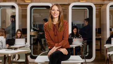 Maven Clinic CEO Kate Ryder sits on a desk in the office