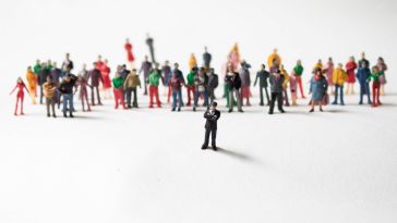 action figure of a person standing in front of an assortment of others in the background