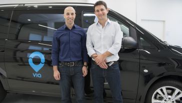 Via CEO Daniel Ramot and CTO Oren Shoval stand in front of a car with the Via logo.