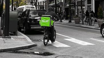 A Relay Delivery courier bikes through the city. 