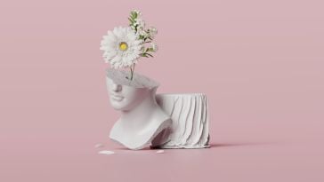 Statue of goddess' head, broken with flowers coming out of the head, on pink background