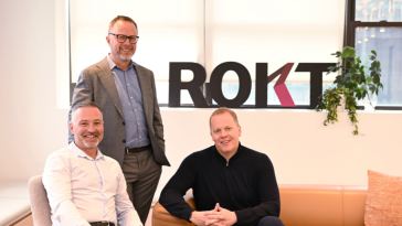 Rokt executive team members pose together for a photo.